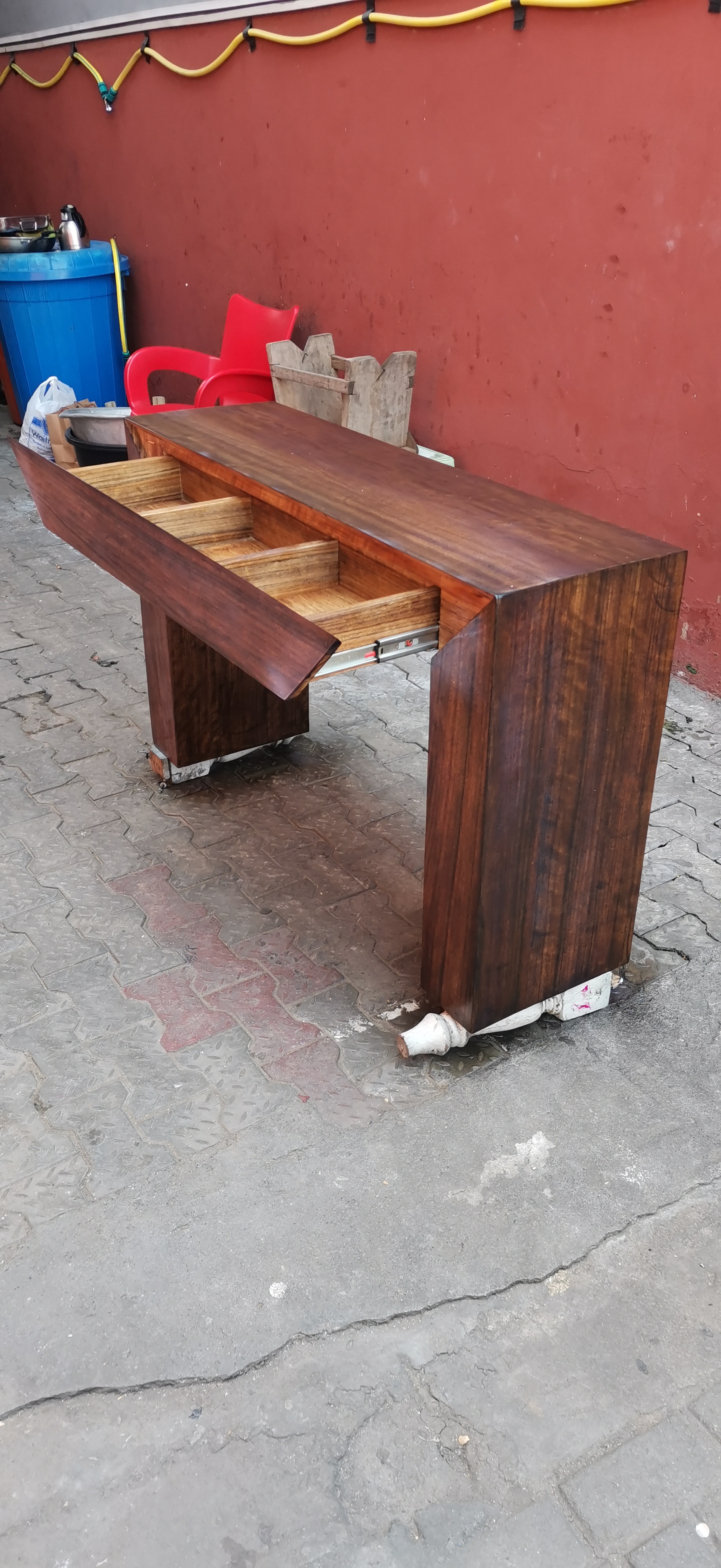 Afromosia slab in the workshop before finishing — raw grain visible
