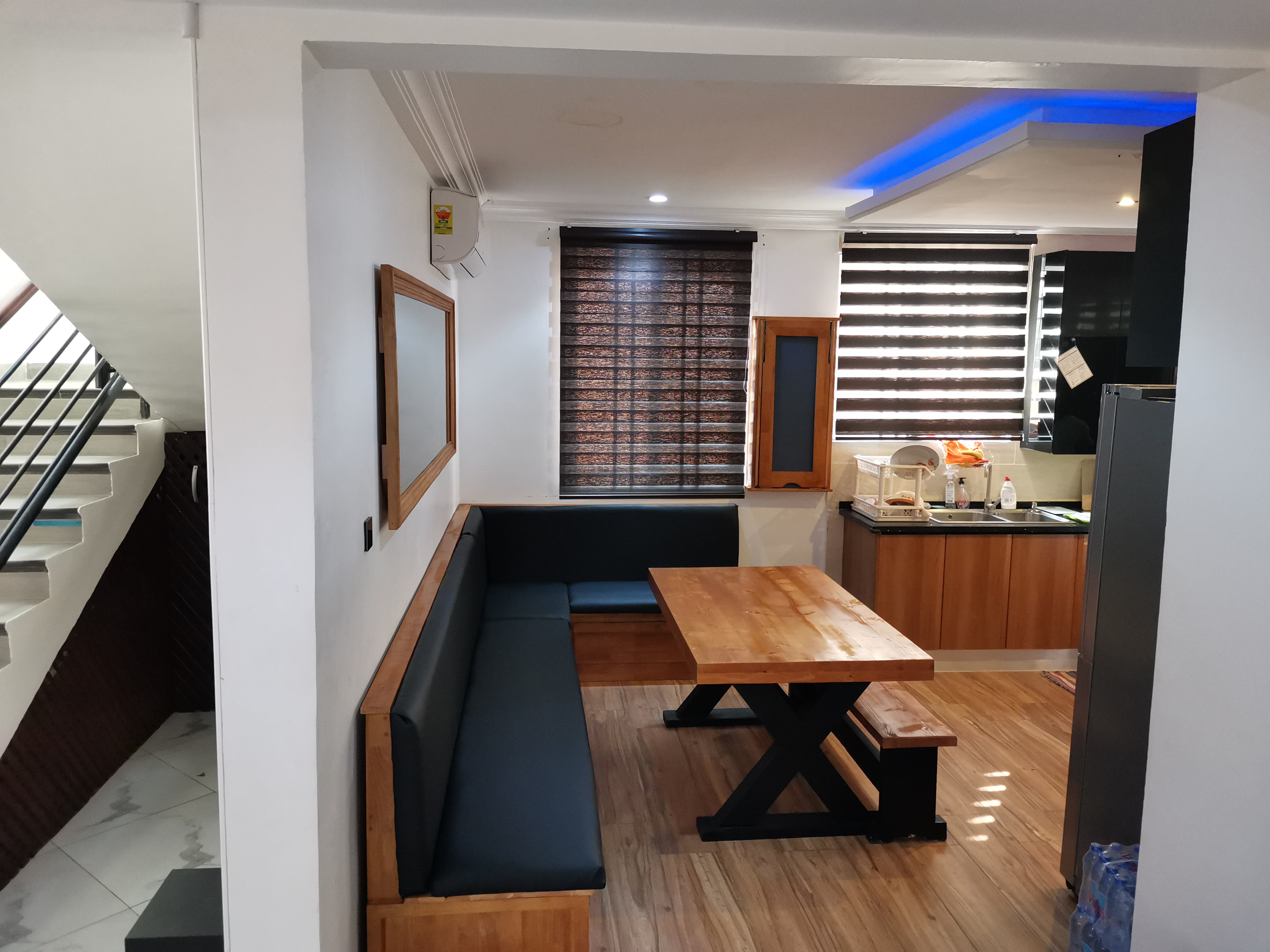 Built-in L-shaped banquette and X-frame dining set installed in Golf Hills Estate, Accra — built by Neewoody Custom Woodwork