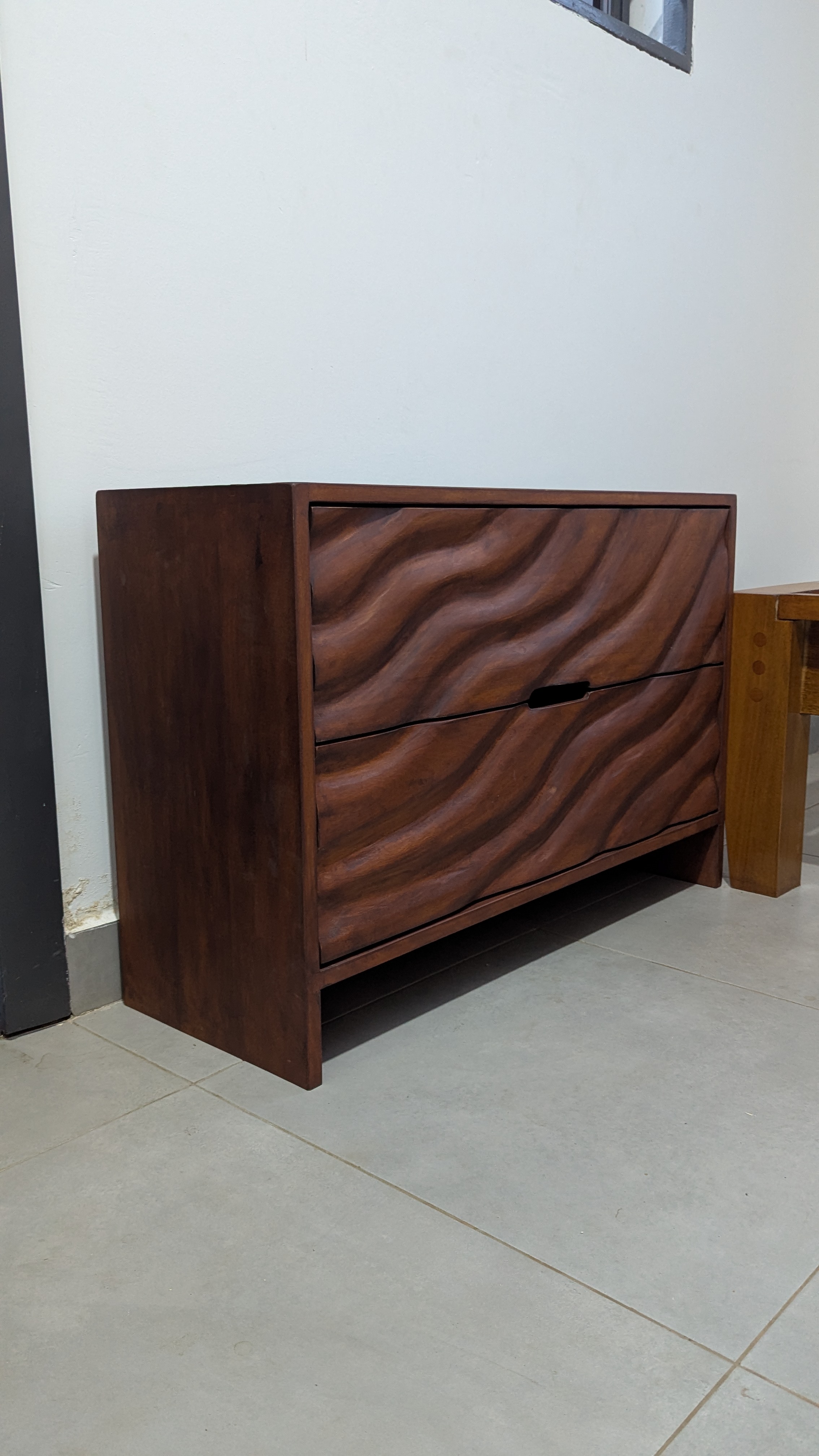 Wave-carved Guarea chest of drawers with integrated recessed pulls — built by Neewoody Custom Woodwork for a private residence in Dome, Accra
