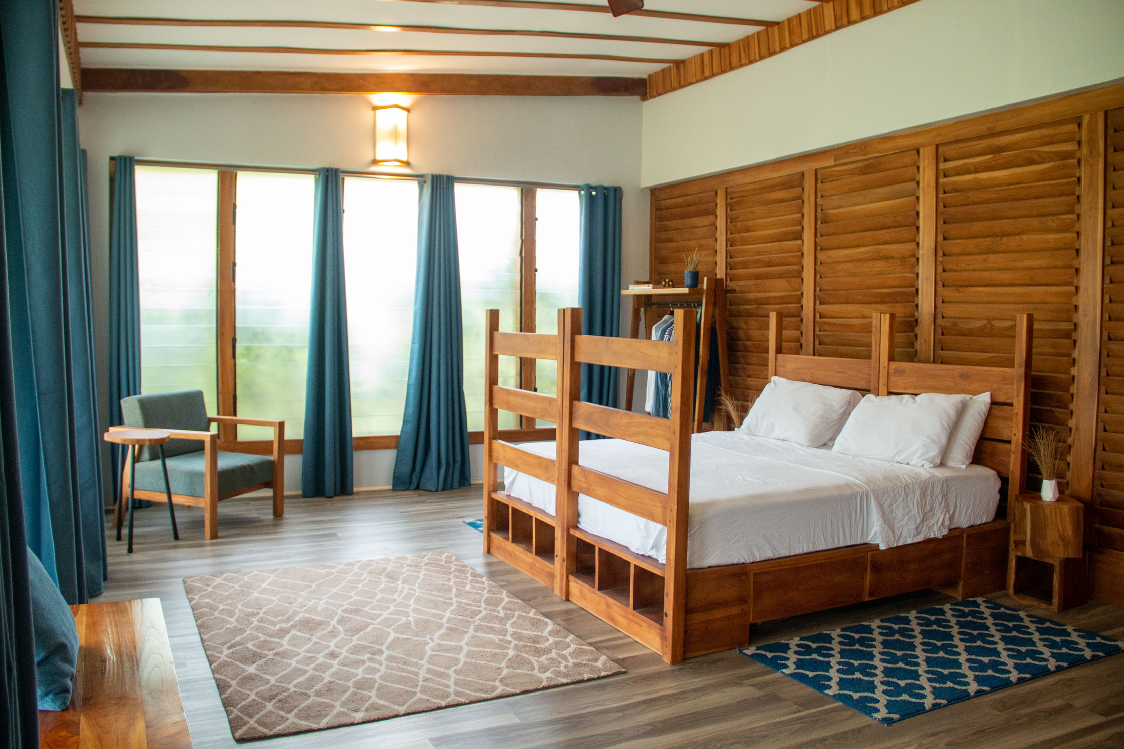 Custom teak storage bed with louvre feature wall in a Sage Centre hostel room